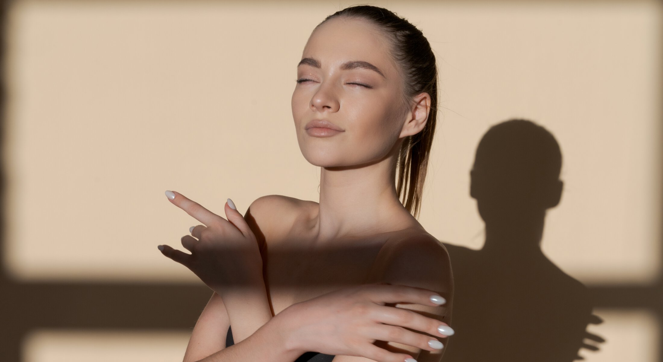 Woman posing with sunlight and shadow across her face